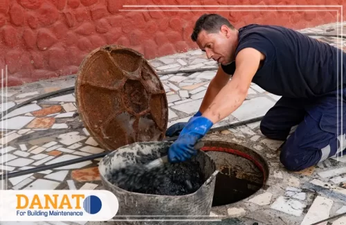 تنظيف مجاري في دبي يظهر الرجل وهو يخلط مادة تنظيف داخل دلو، وهو يركز على العمل بحذر للحفاظ على أداء المجاري بشكل صحيح. تعتبر هذه العملية جزءًا من الخدمات المهنية التي تقدمها شركات تنظيف المجاري لضمان تصريف المياه بشكل فعال