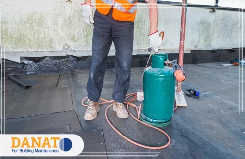 عزل الاسطح بالبيتومين في الفجيرة 0545248958 شركة دانات اللؤلؤ عاملًا يقوم بتركيب مادة عزل الأسطح باستخدام جهاز لحقن البيتومين. يتم تنفيذ هذه العملية بشكل دقيق لتوفير حماية فعالة. يعتبر عزل الاسطح بالبيتومين في الفجيرة من الحلول الموثوقة