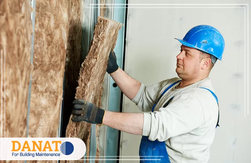 عازل صوت ارضي في ابوظبي دانات اللؤلؤ 0545248958 يقوم الفني بتركيب لوح عازل من مادة طبيعية، مما يدل على دوره في تحسين العزل الحراري أو الصوتي في المباني