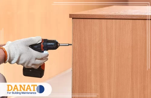نجار فك وتركيب اثاث في عجمان 0545248958 دانات اللؤلؤ فني يستخدم الدريل لتثبيت الأثاث الخشبي بدقة ضمن خدمات شركة فك وتركيب اثاث في عجمان.